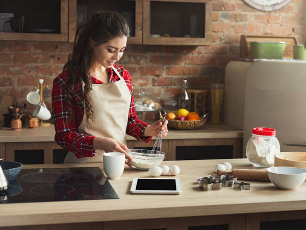 Woman mixing baking ingredients together in home kitchen