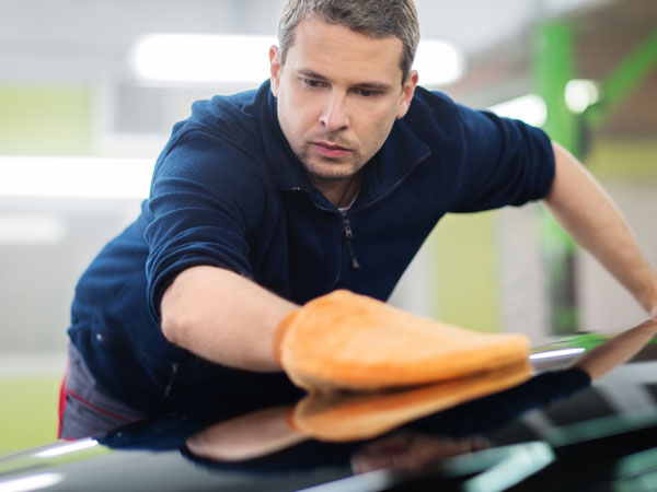 man getting a perfect shine on a car