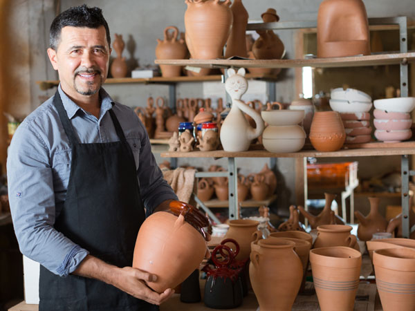 man standing infront of a ceramic display