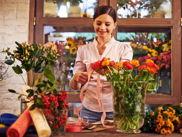 Woman arranging flowers in vases