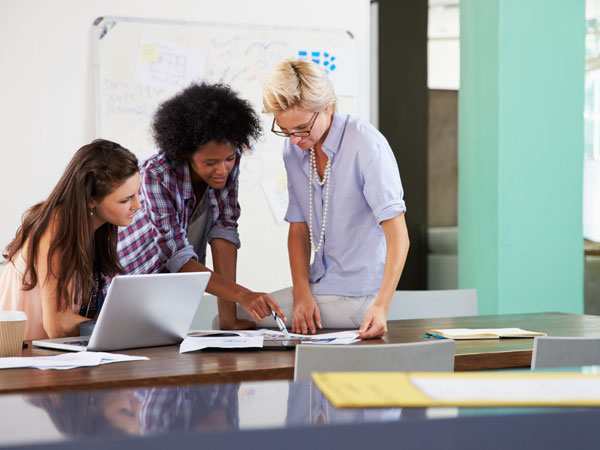 three women in an office translating documents