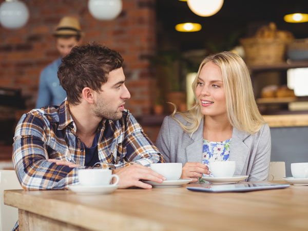 a man and women in a coffee shop having a conversation