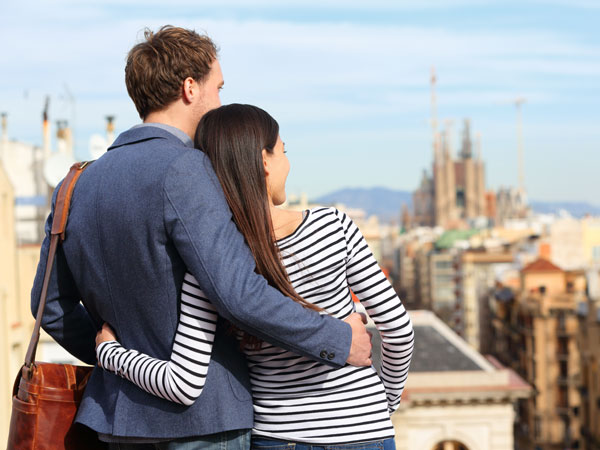 Man and woman embrace while enjoying view of foreign city